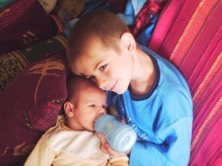 chrys qui donne le biberon a son peti frere